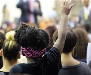 child raises hand at meeting